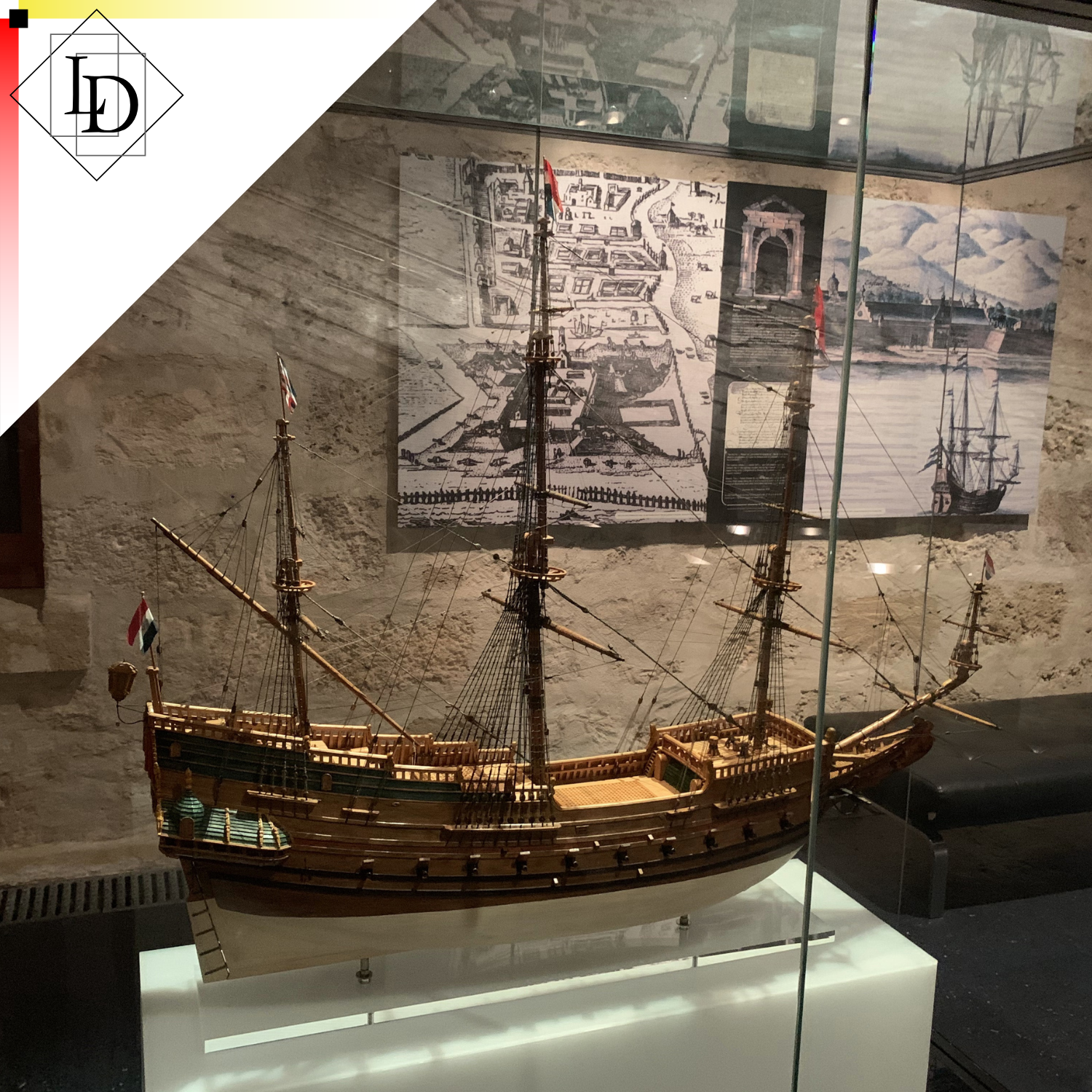 The image comprises the LD Logo against a white triangle in the top left, overlaying a photograph of a model of an early Dutch exploration vessel.